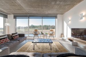 Modern villa living room couch with pool and deck views