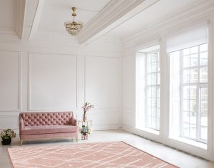 Luxury rich living room interior design with elegant classic furniture and wall decorations. Large light white room with big window