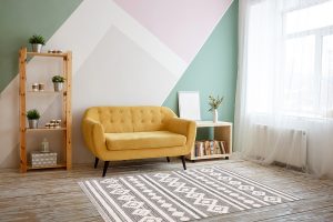 Nice living room with couch, carpet, green plant on a bookcase.